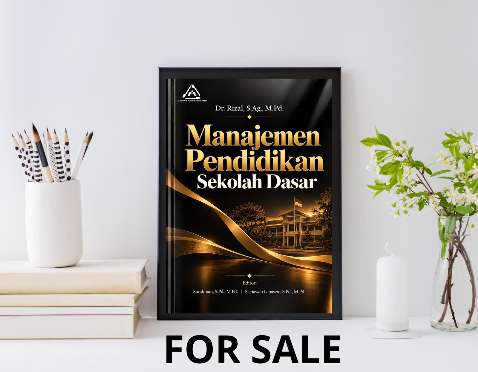 Sampul Manajemen Pendidikan Sekolah Dasar bernuansa hitam dan emas, ditampilkan dalam bingkai di atas meja dengan buku dan tanaman.