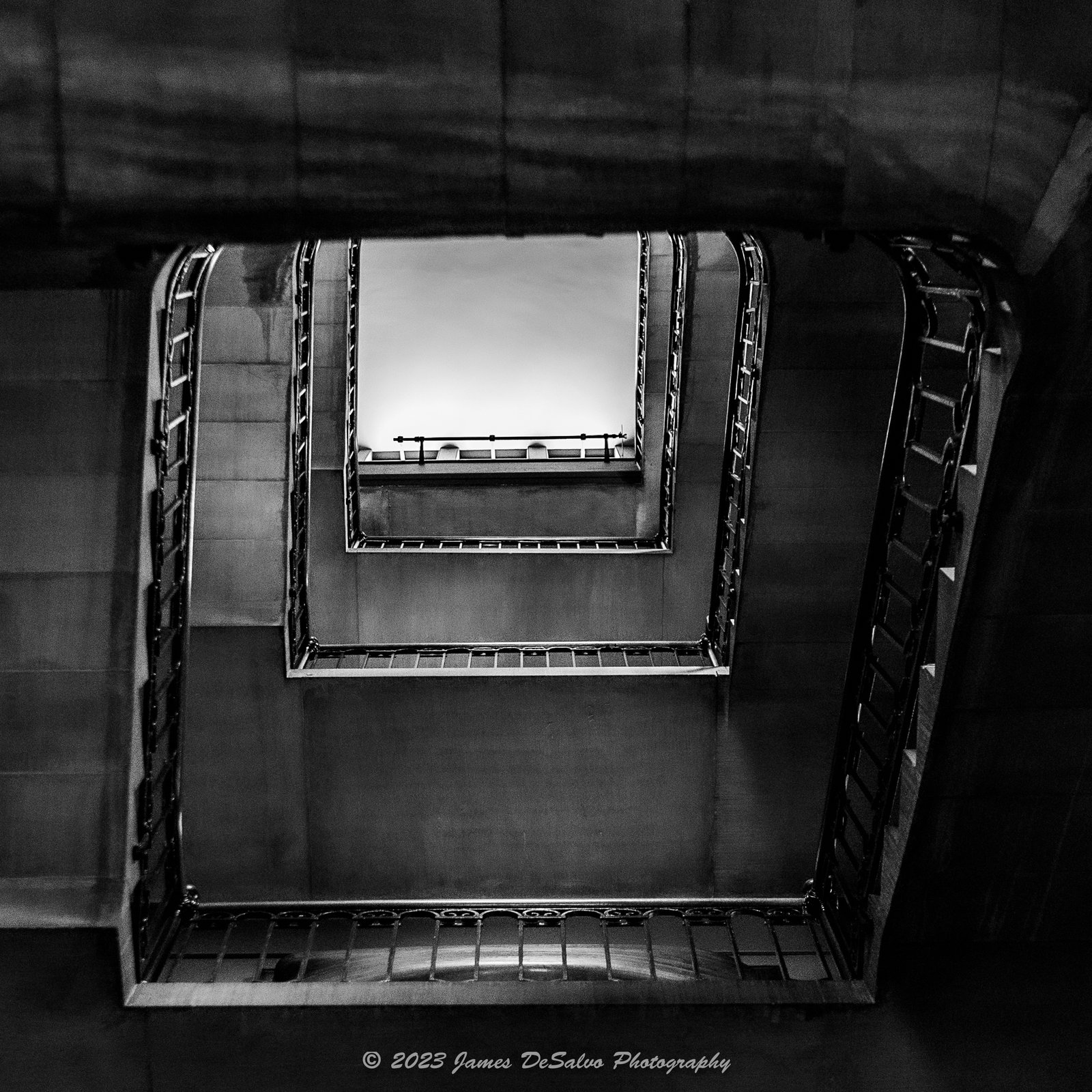 White concrete spiral staircase viewed from above with soft shadows