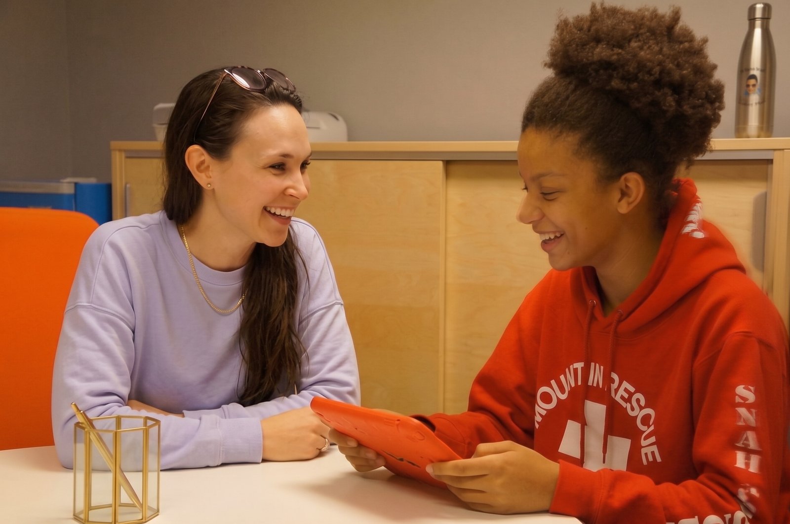 A speech-language therapist and client smiling together during a collaborative learning session