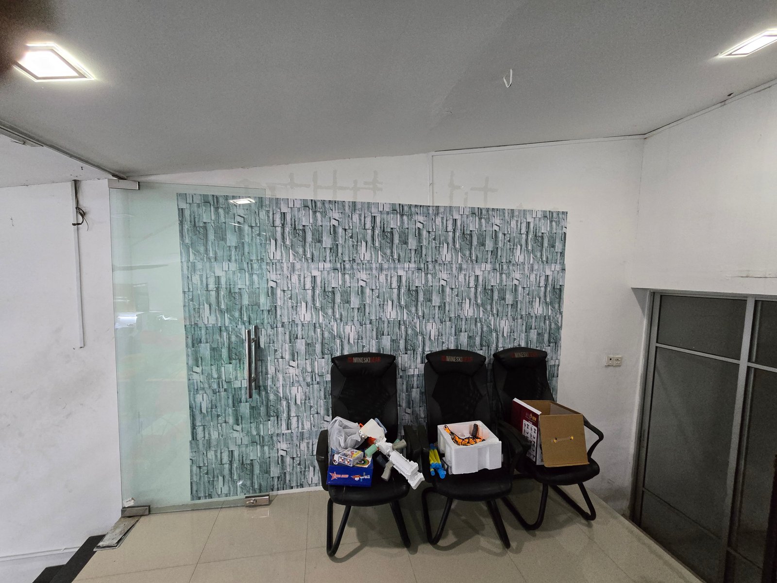 Reception area at Emart Brickfield with commercial glass partition door and stone effect feature wall