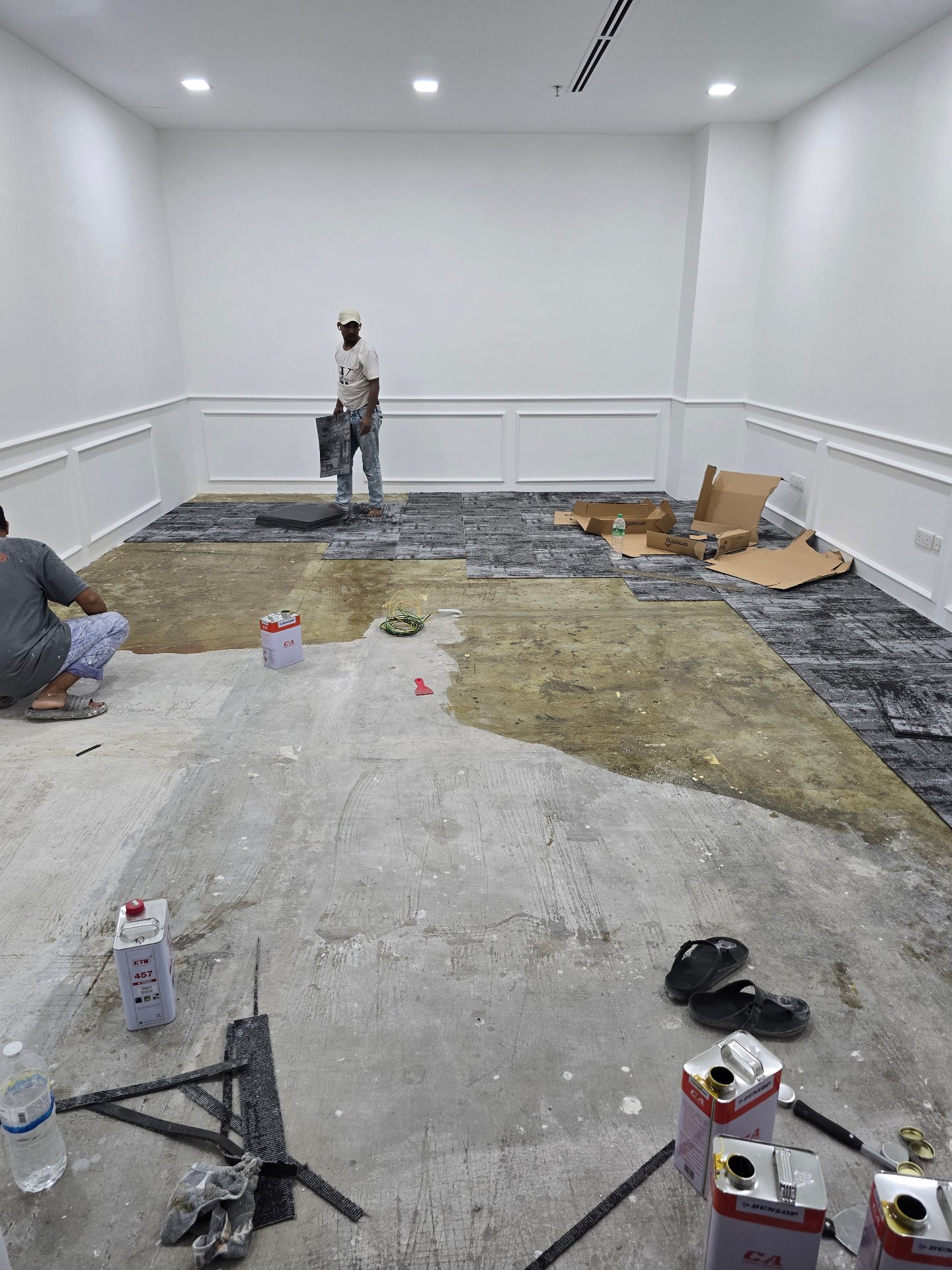 Carpet tile installation with freshly painted white walls at GD Properties KLCC Showroom