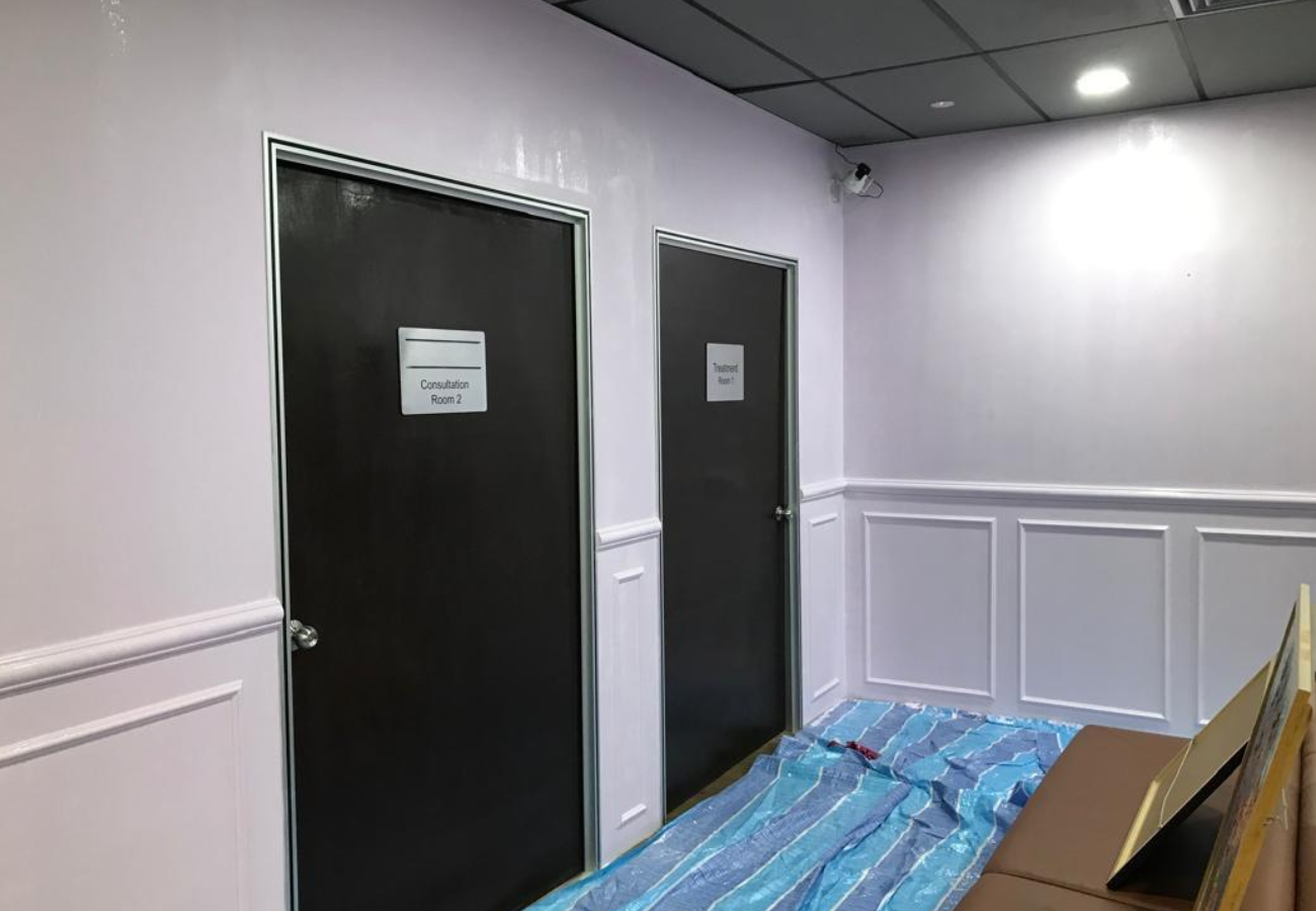 Before: Clinic corridor with consultation room doors during fit-out