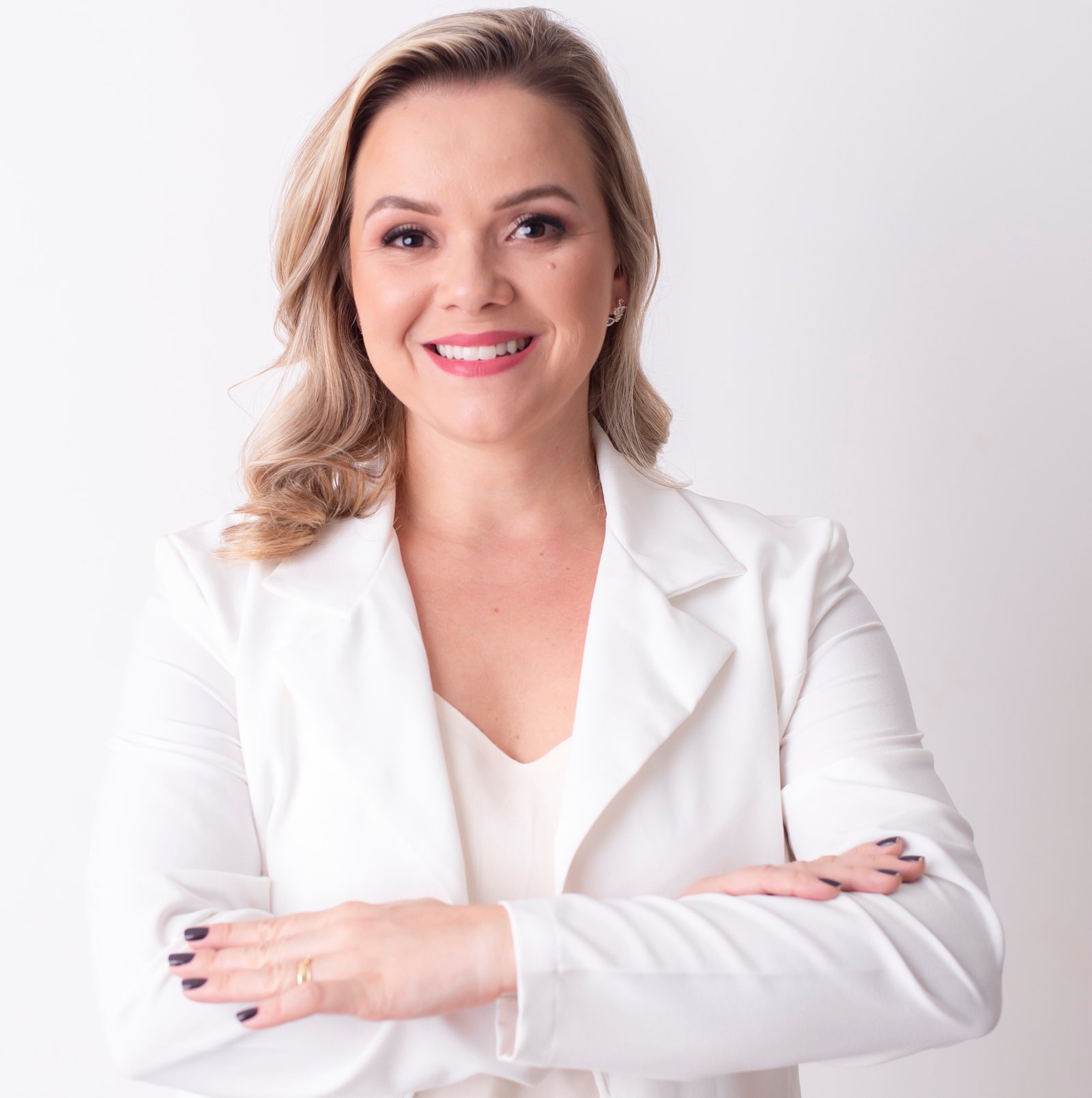 Dra. Amanda Pinheiro - Fisioterapeuta Especialista sorrindo de blazer branco