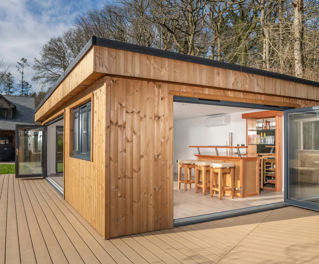 Modern garden room with glass doors and wooden decking