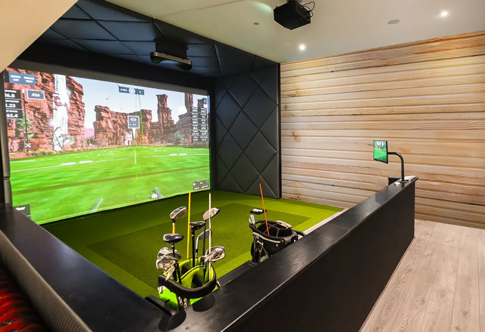 Hobby room garden building with a golf simulator screen and turf