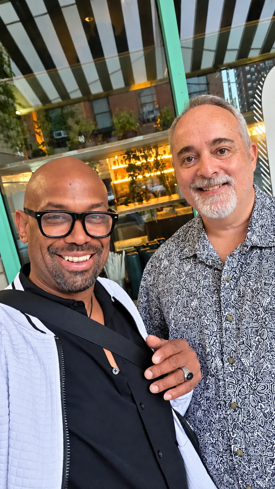 Corey Wesley standing with a friend outside a glass-fronted restaurant