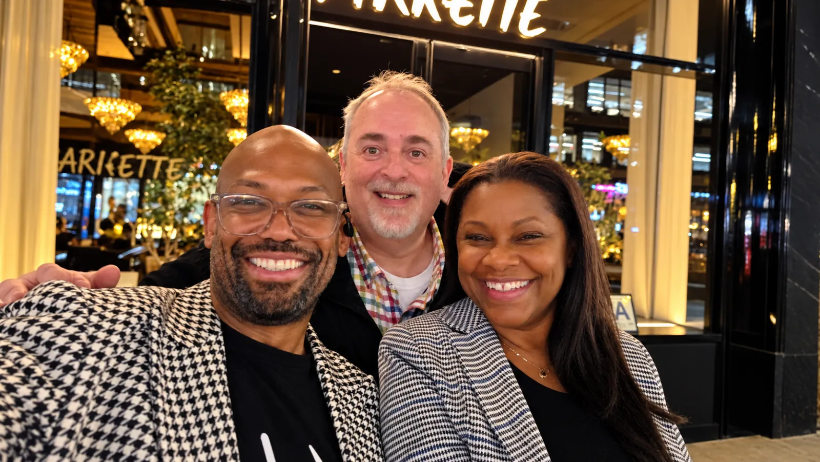 Corey Wesley with two friends outside a restaurant at night