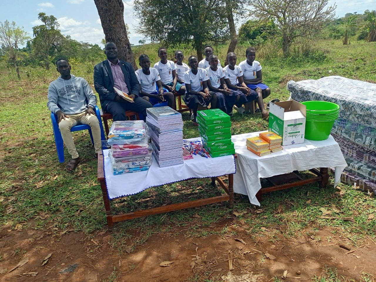 Staff members and beneficiaries at textbooks, exercise books, and educational materials distribution event