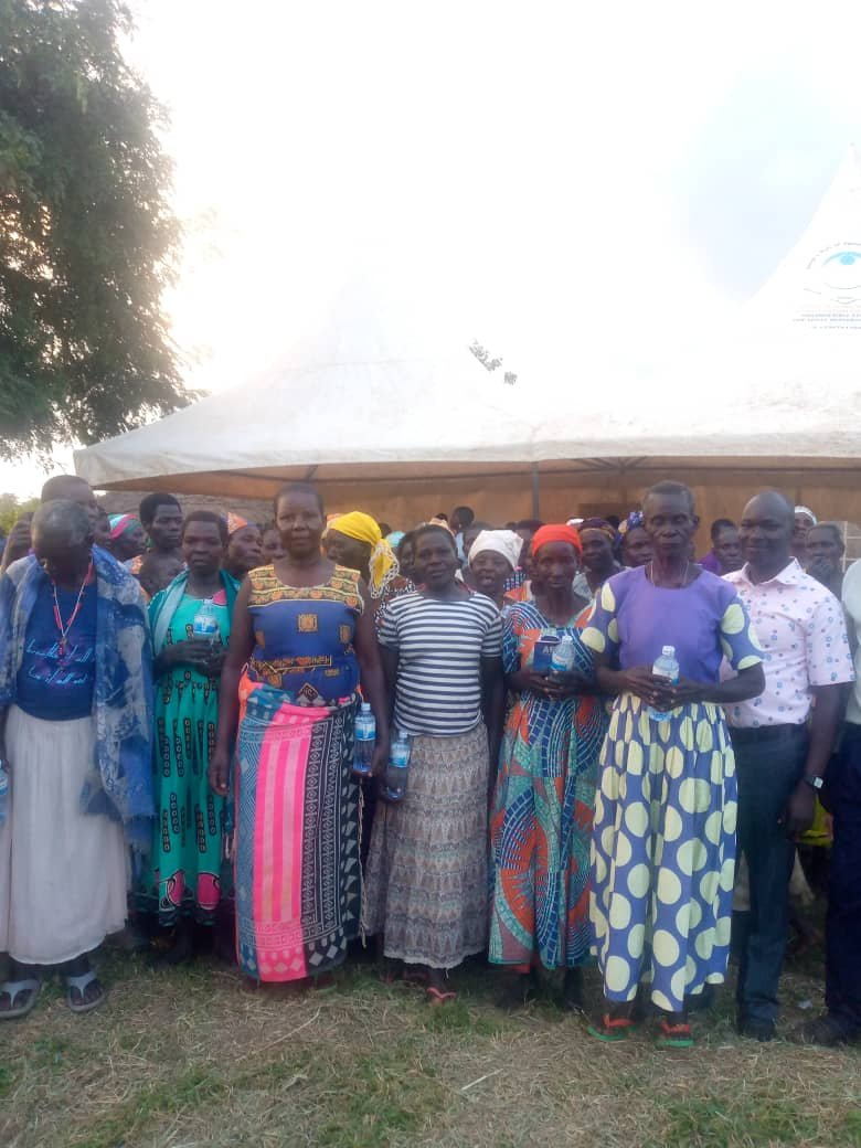Community gathering under tent with diverse group in colorful traditional clothing