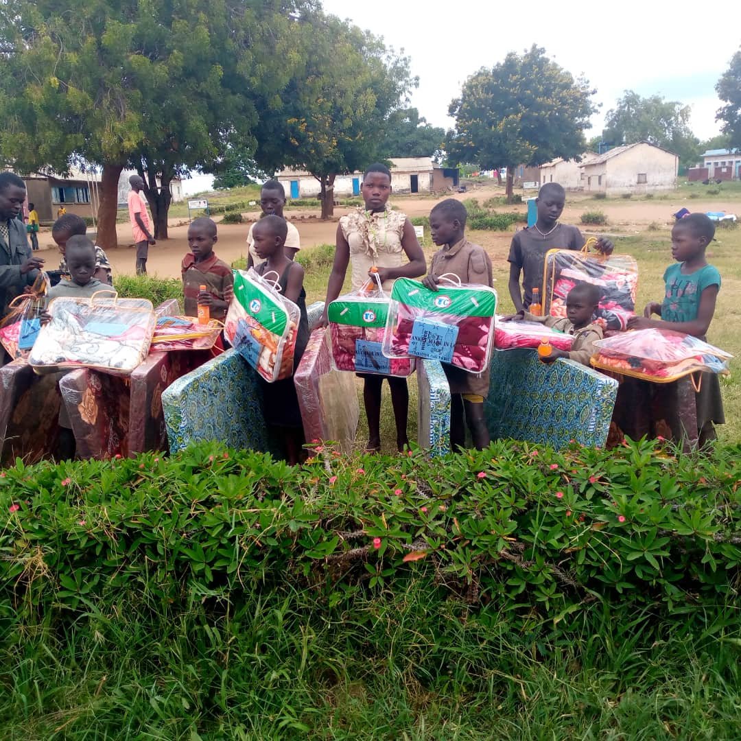 Beneficiaries pose with their mattresses and bed covers