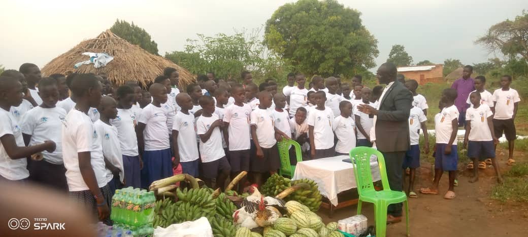 Children eating meals at community gathering under tent