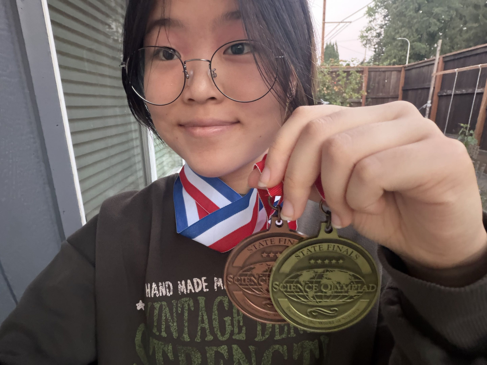 Hannah Lee holding Gold and Bronze medals from the 2025 Oregon Science Olympiad State Finals.
