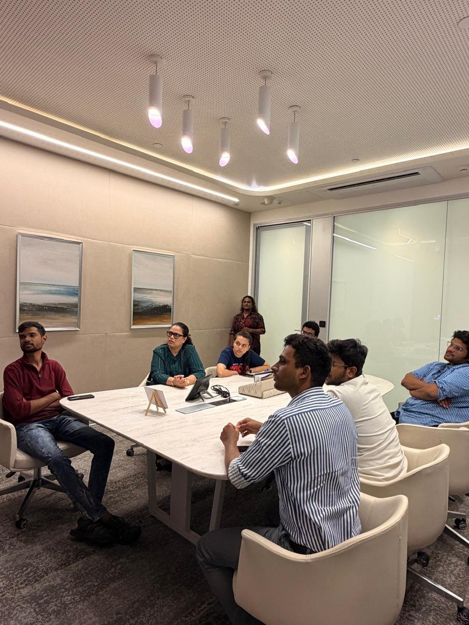Students engaged in discussion around the marble meeting table