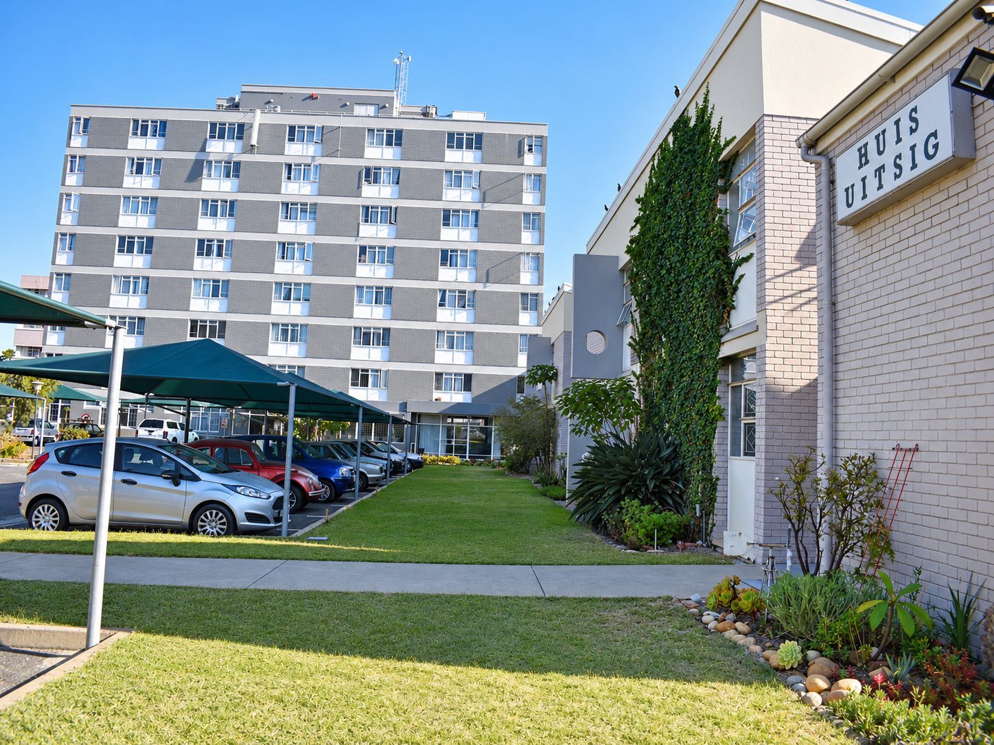The neat white buildings and gardens of Huis Uitsig in Parow North