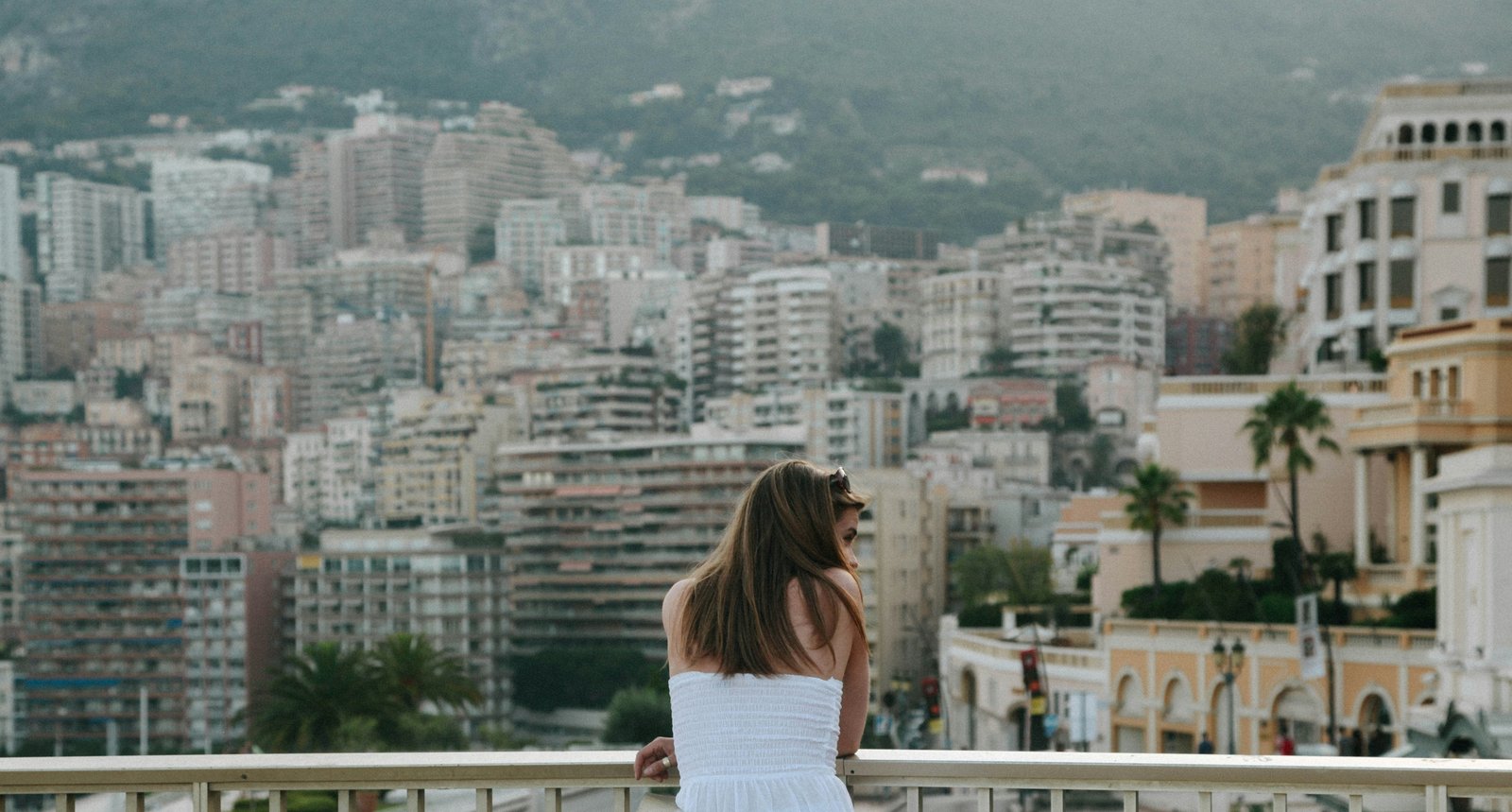 Monaco cityscape from elevated viewpoint with woman overlooking the principality