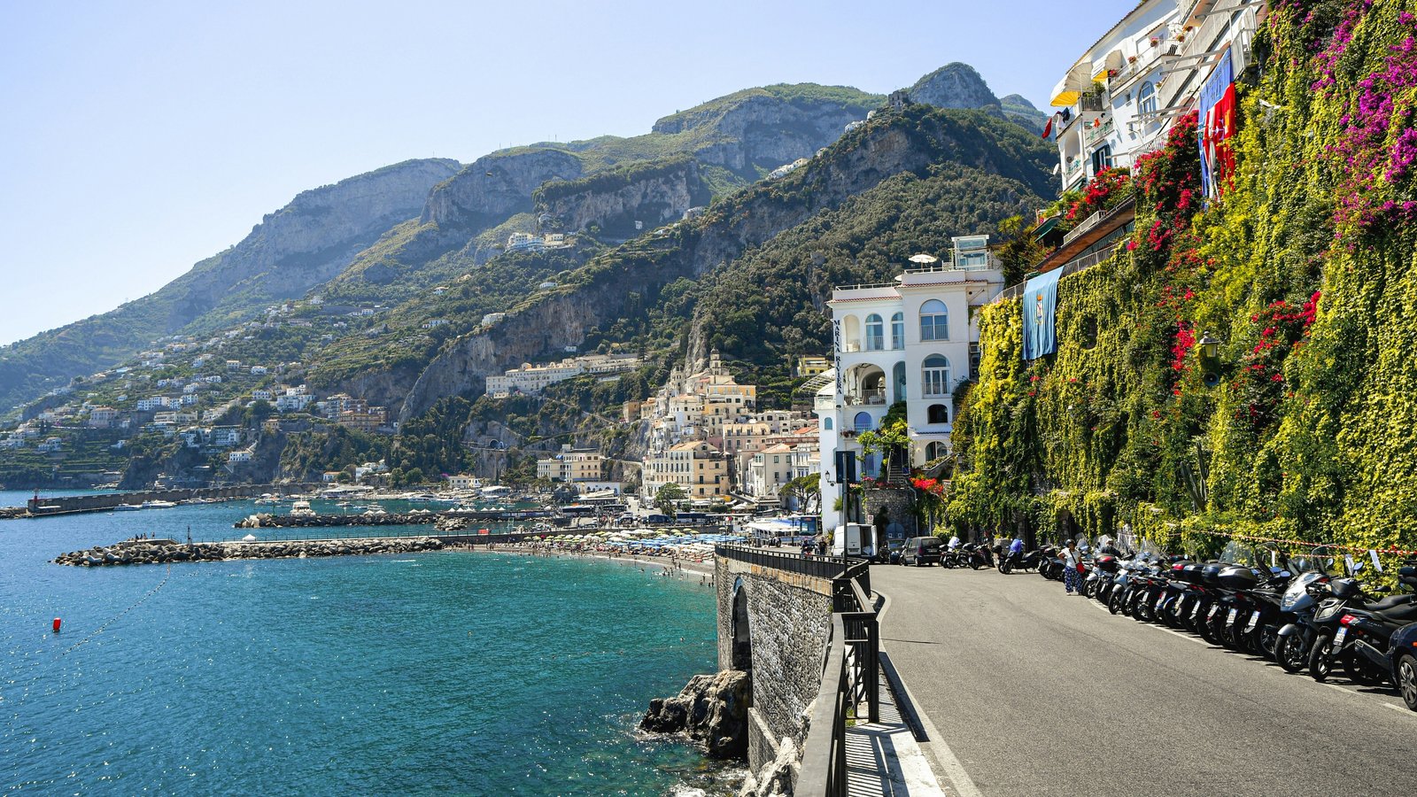 Amalfi coastline with ivy-covered white buildings, turquoise water, dramatic cliffs