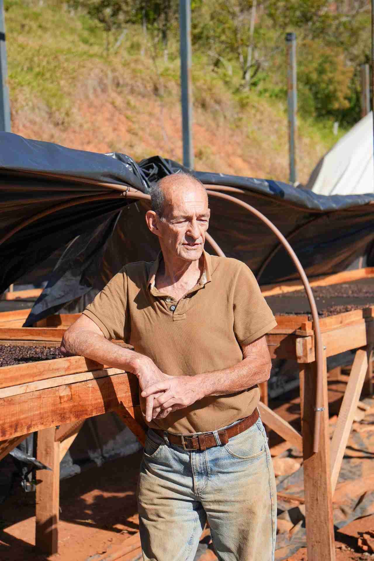 Produtor ao lado do terreiro de secagem na fazenda