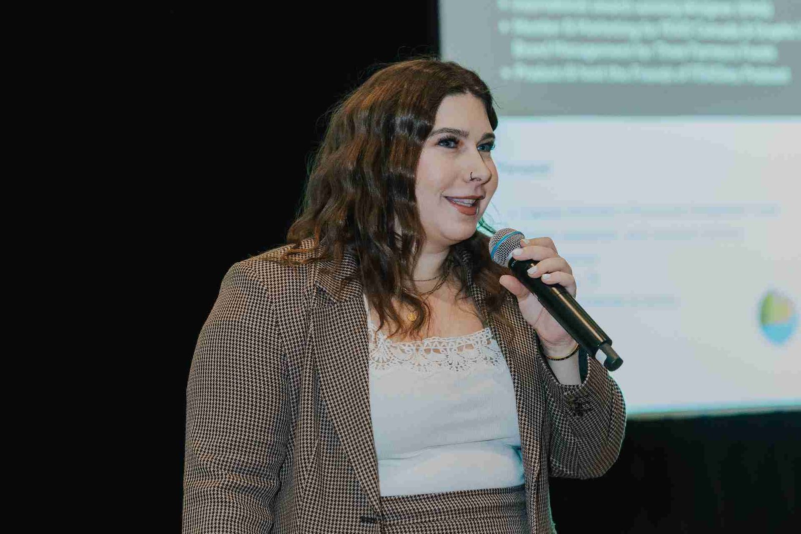 Lindsay Toth speaking into a microphone at a conference