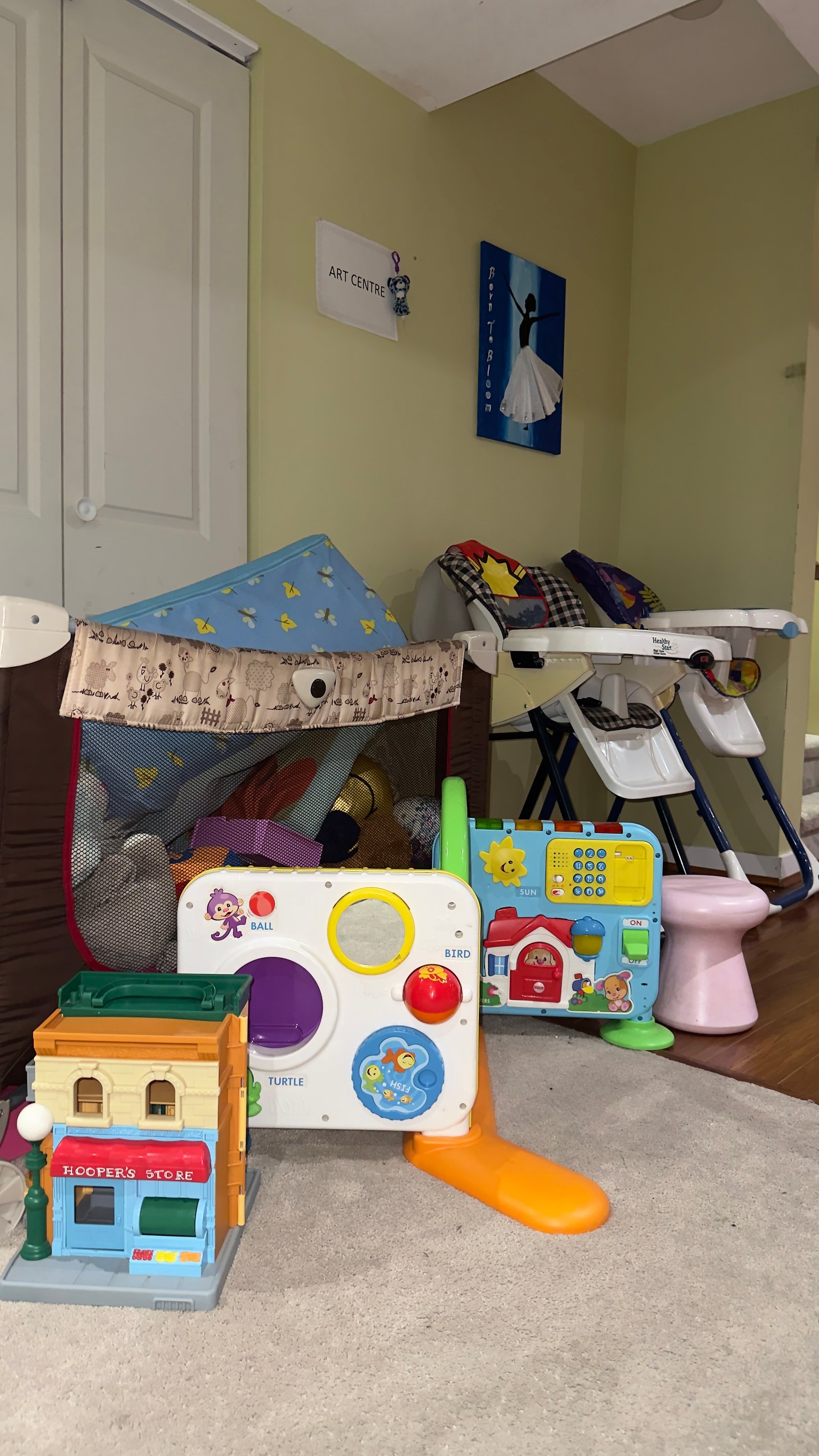Soft play area with activity panels, toys, and high chairs for younger children