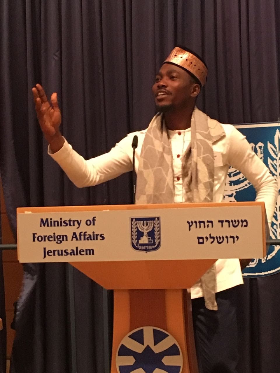 Joe Quarcoo speaking at a Ministry of Foreign Affairs lectern in Jerusalem during the 2017 MASHAV programme.