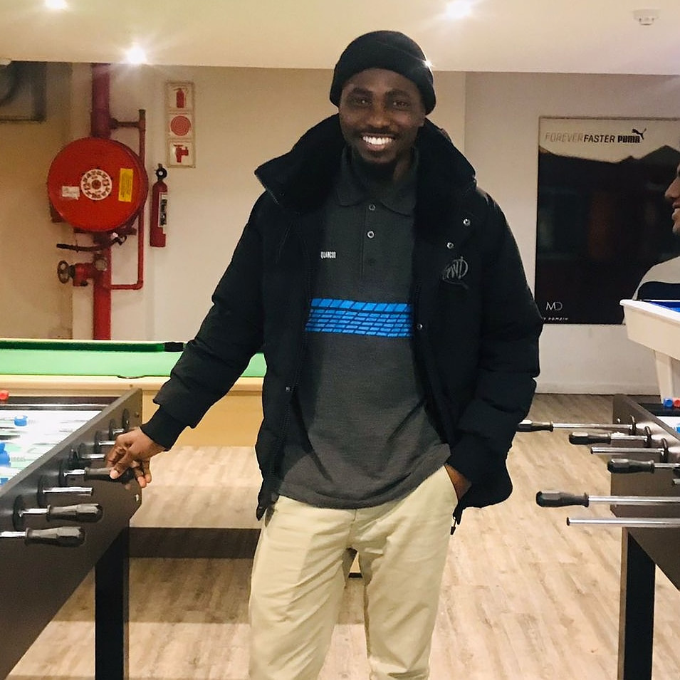 Joe Quarcoo smiling in a contemporary informal portrait.