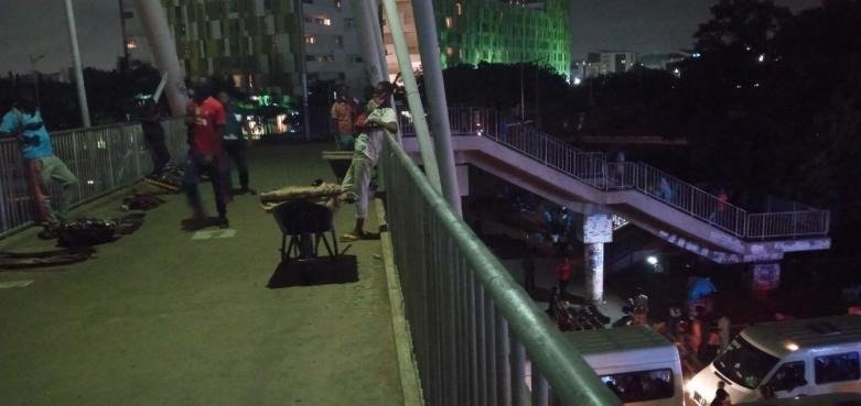 Comparative daytime and nighttime views of street trading beside a major road in the Accra Mall Enclave.