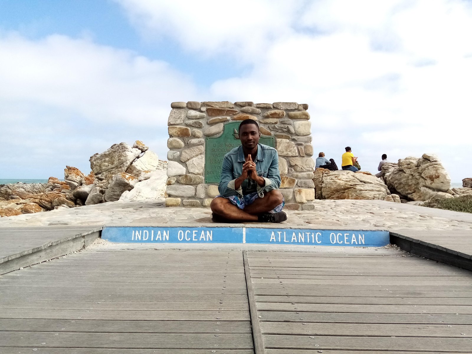 Joe Quarcoo at the Cape Agulhas marker between the Indian and Atlantic Oceans in South Africa.