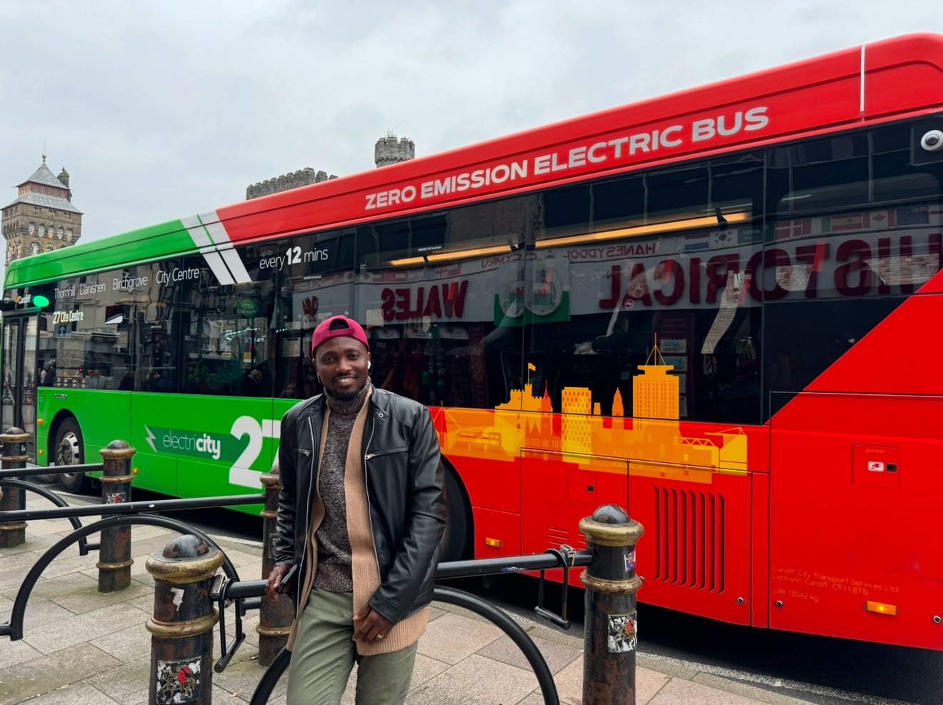 Joe Quarcoo standing beside a zero-emission city bus in Cardiff.