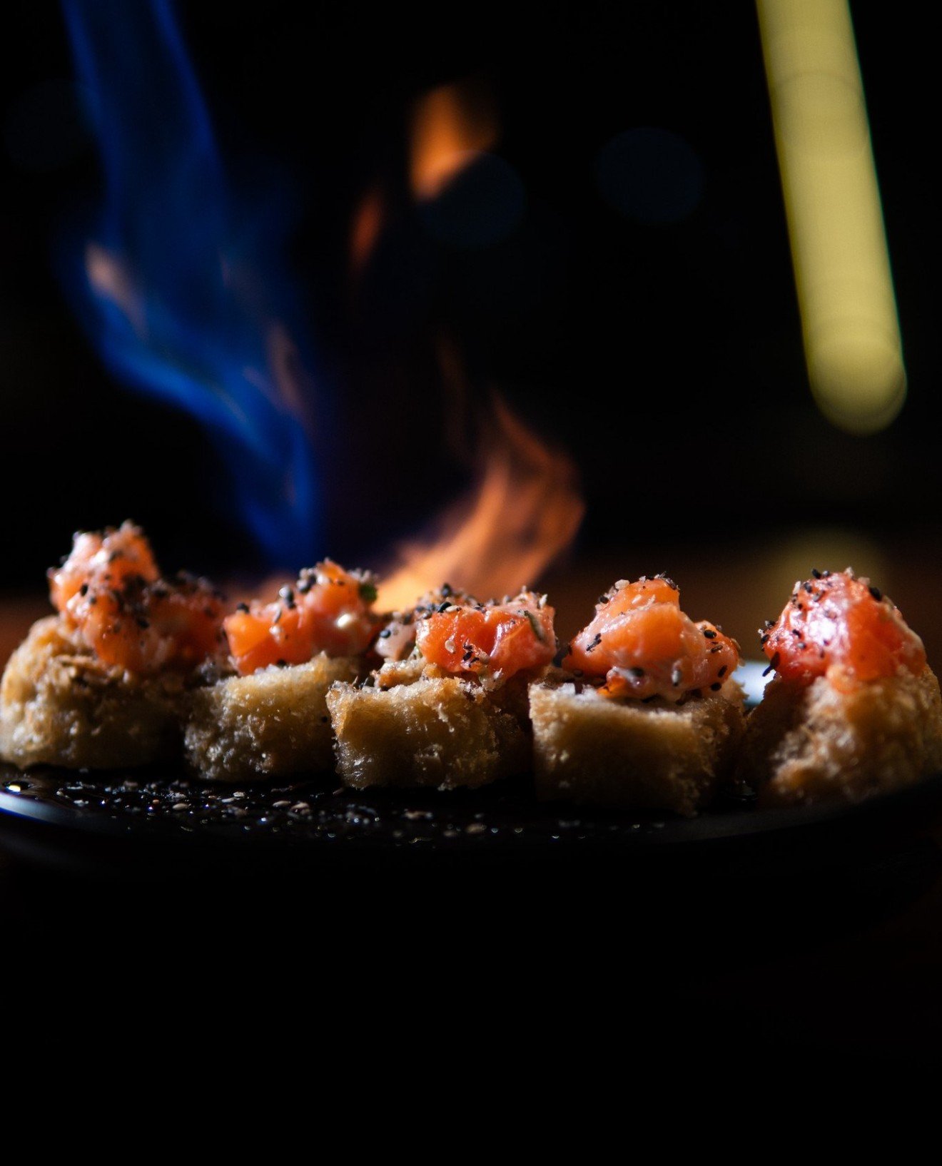 Sushis flambados com chamas azuis e laranjas