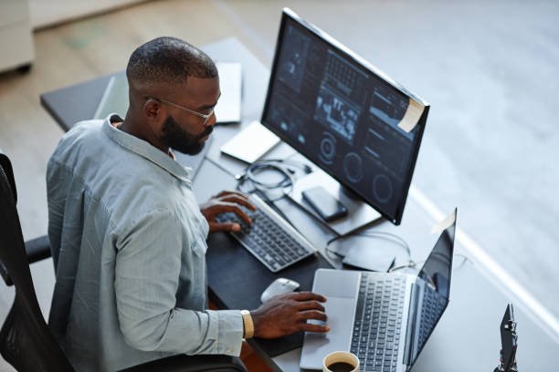 Man working on sermon notes at a computer with two monitors