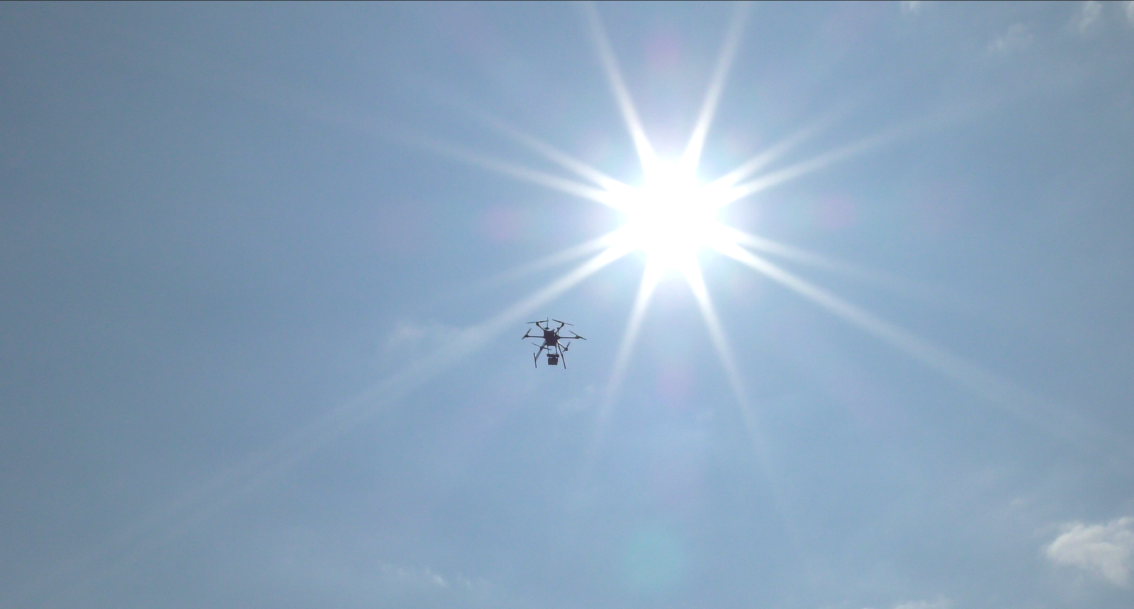 Drone silhouette against bright sky