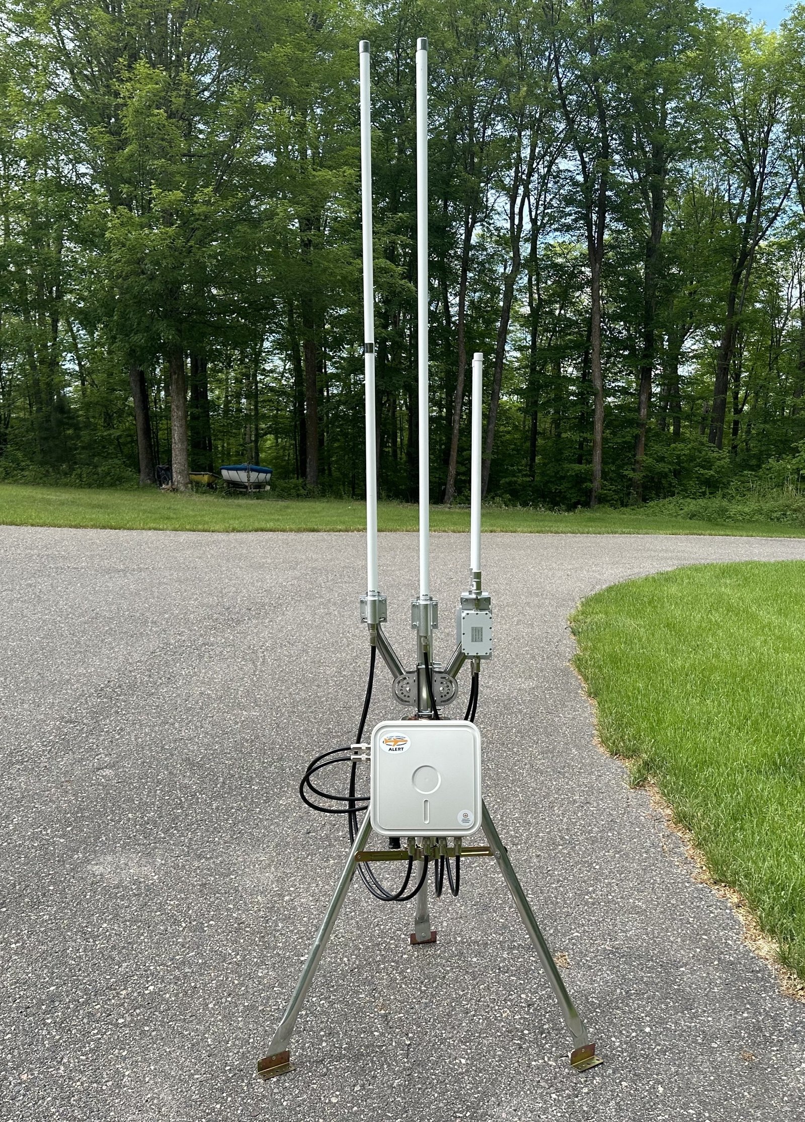 Outdoor detection unit mounted on brick wall with antennas and mounting hardware
