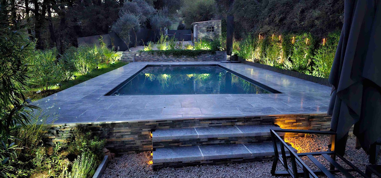 Transformation piscine moderne après rénovation PVC armé, éclairage nocturne et terrasse pierre