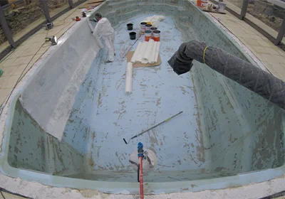 Application du mat de verre sur une coque de piscine polyester