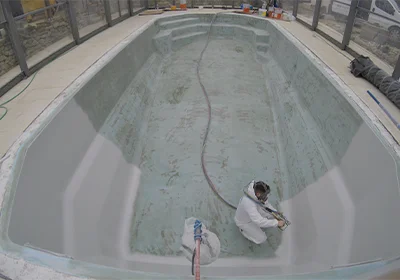 Application du Top Coat sur une coque de piscine polyester
