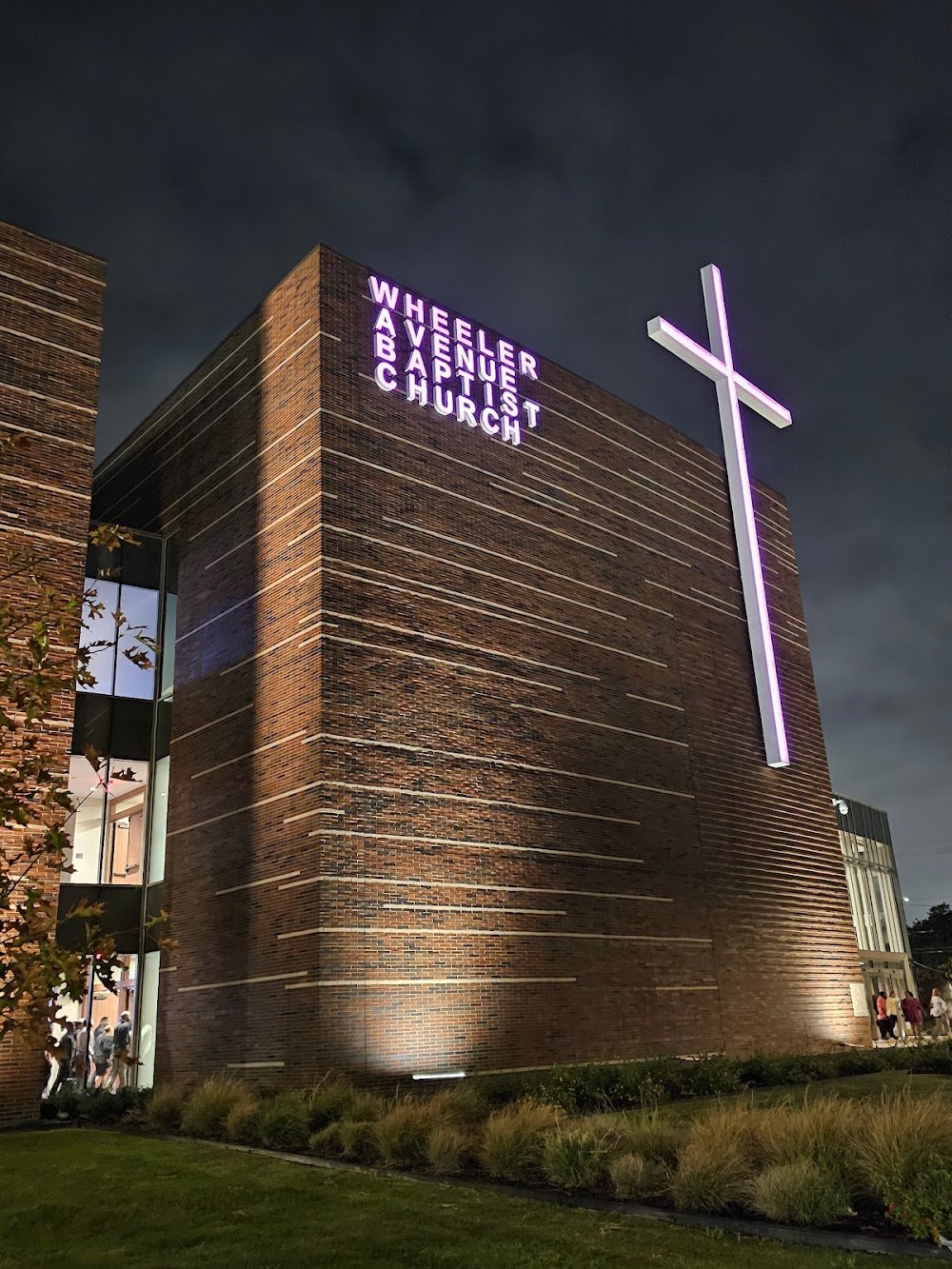 Wheeler Avenue Baptist Church exterior at night, with illuminated cross and sign