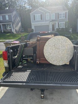 Truck bed filled with old furniture and large items safely secured for hauling