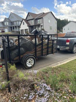 Utility trailer loaded with junk and household items