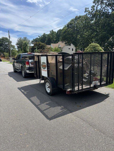 Trailer loaded with junk positioned next to truck