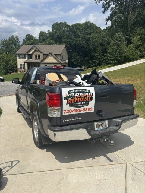 North Georgia Rapid Removal Junk Co. truck loaded with junk in residential driveway