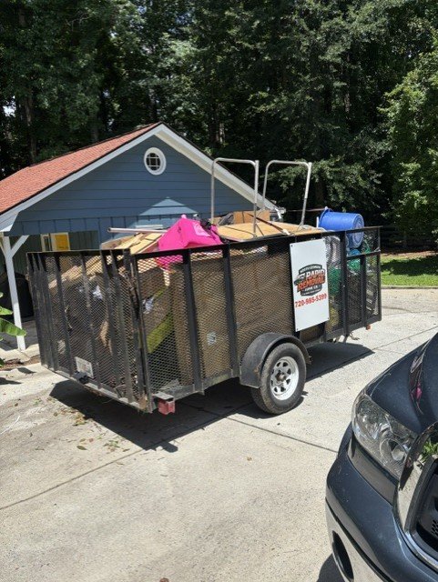 Trailer loaded with junk and pink items ready for disposal