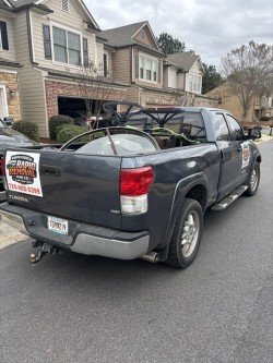Truck parked in residential driveway loaded with items