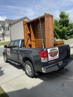 Large wooden cabinet or furniture piece loaded on truck