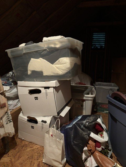 Attic with stacked boxes and storage containers before removal