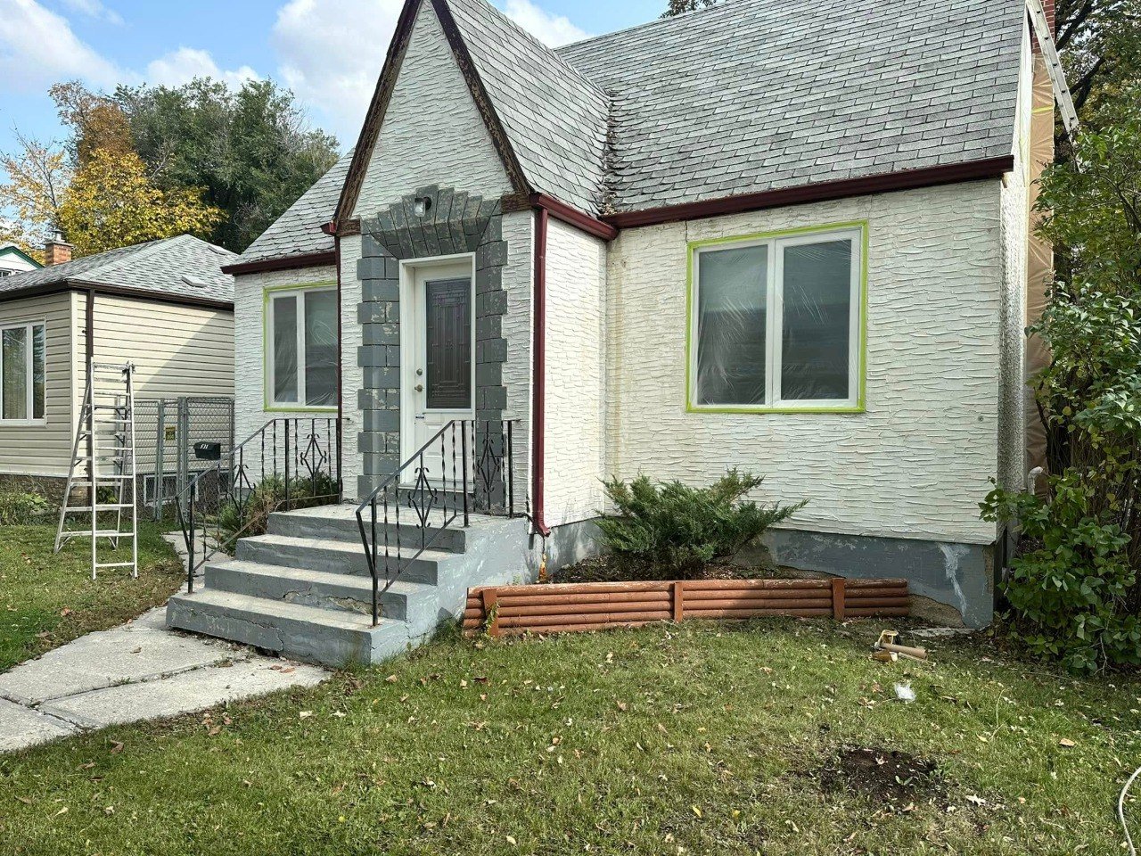 Stone-front cottage with freshly painted siding