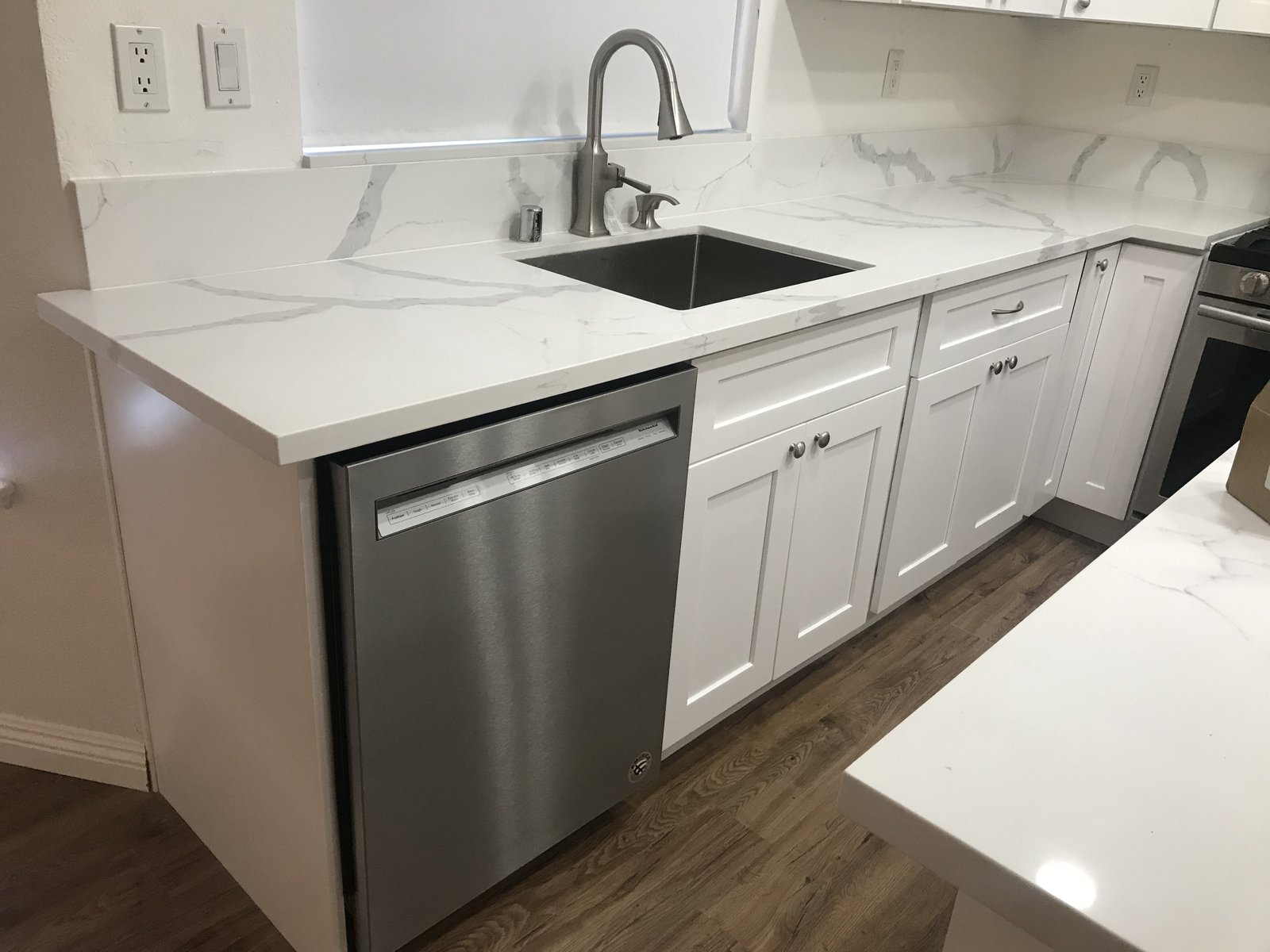After: white shaker cabinets and quartz-look countertop
