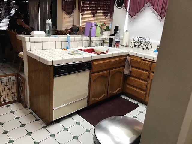 Before: kitchen with oak cabinets and tile countertop