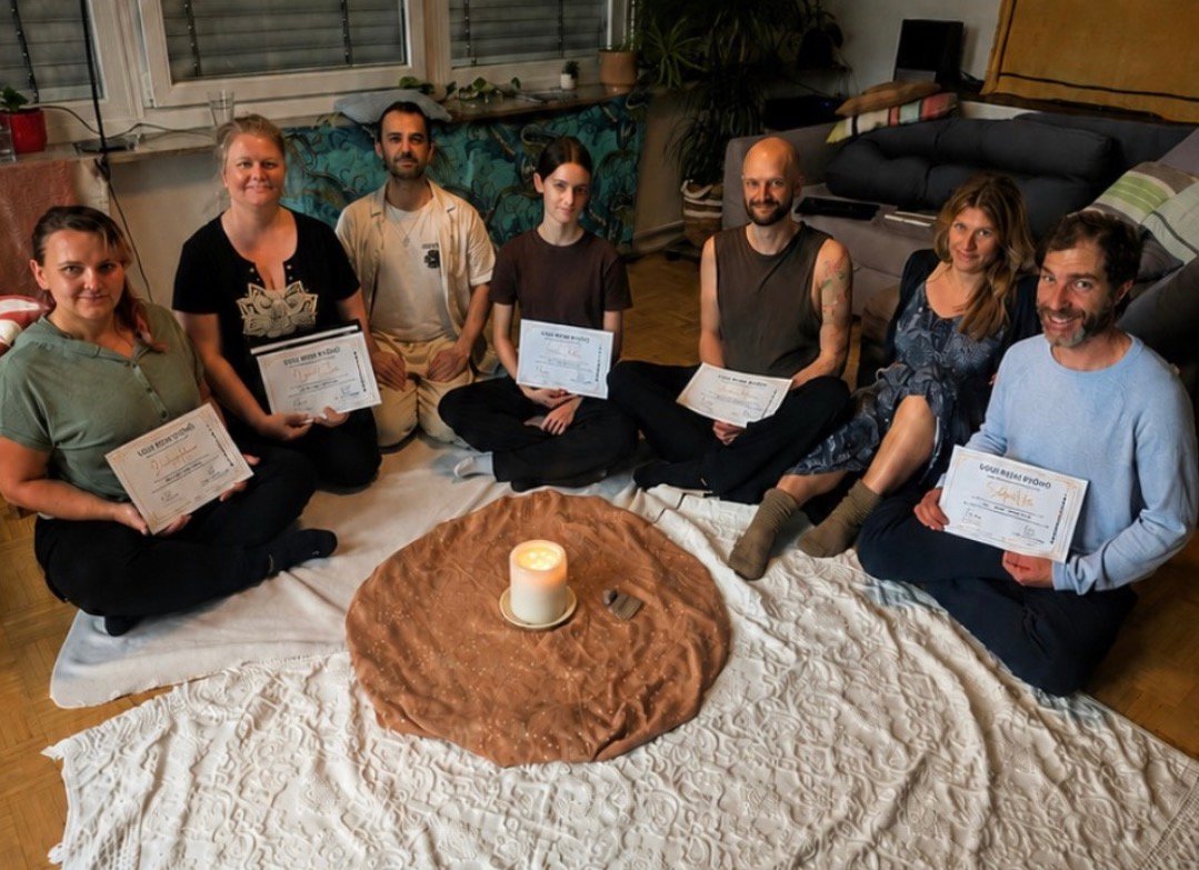 Gruppe von Reiki-Seminar-Absolventen, die im Kreis sitzen und ihre Zertifikate halten