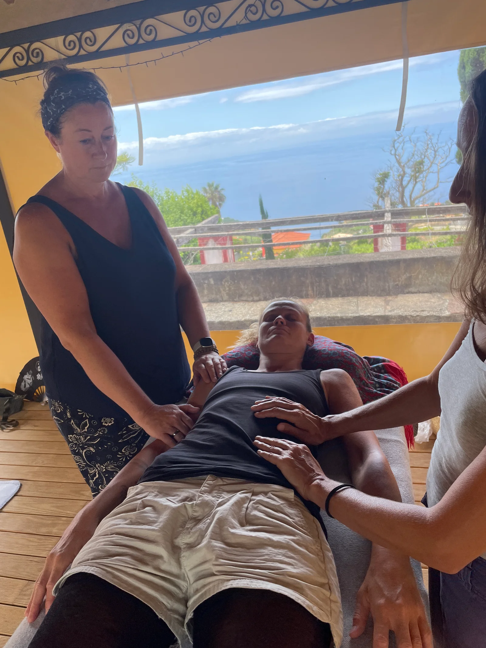 Reiki-Behandlung mit zwei Anwendern und Meerblick im Hintergrund