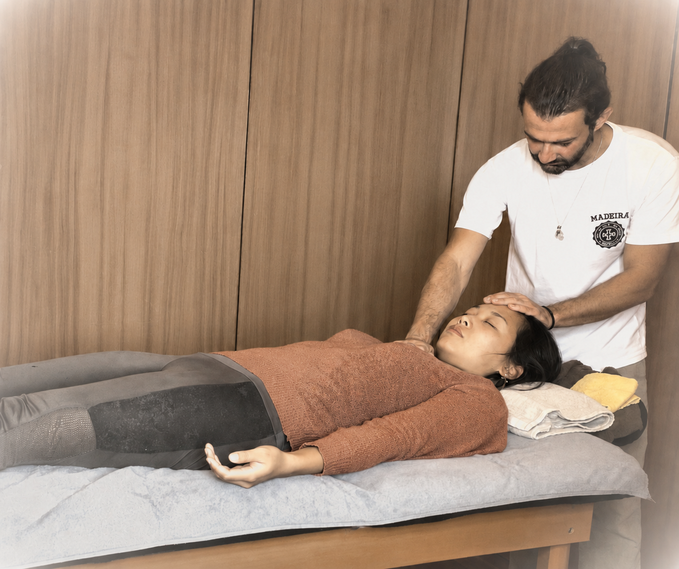 Andrej bei einer traditionellen japanischen Reiki-Behandlung eines auf einem Behandlungstisch liegenden Klienten